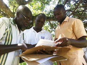 Muzei, Dr. Mwanika, and Land Board attorney going over final paperwork for tomorrow's hearing.