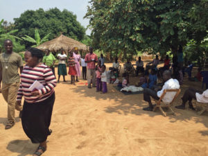 Simon Peter (left) and Pilgrim's Doris Otim with the Ojaman family